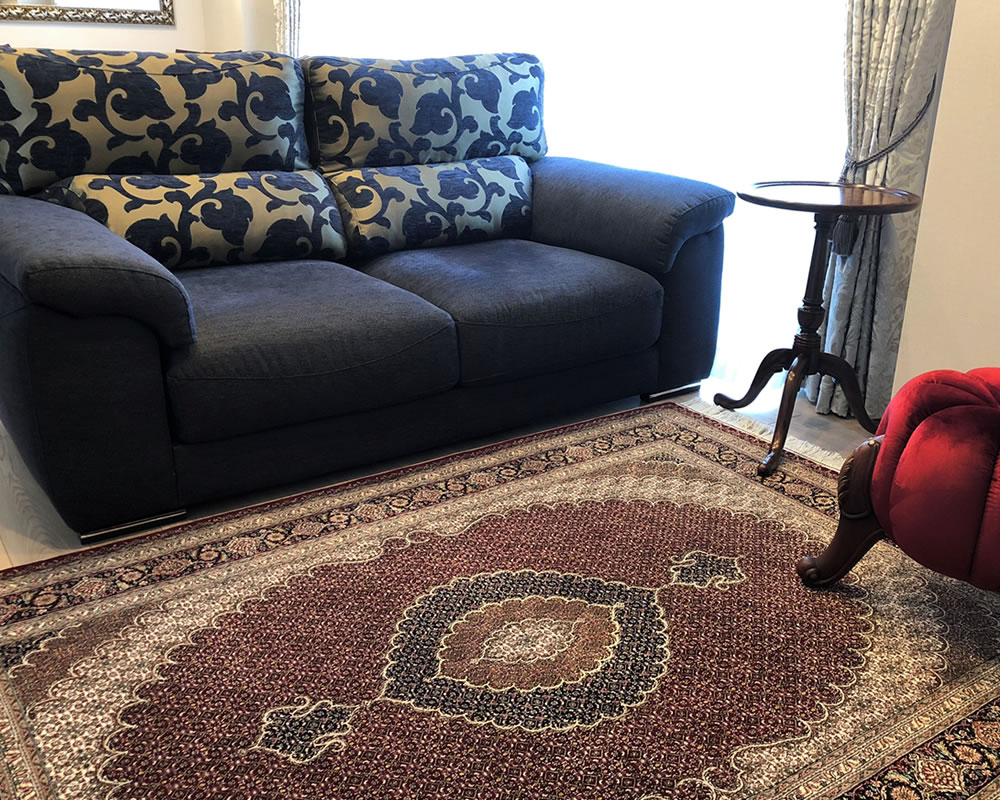 ダークブルーのソファと赤いペルシャ絨毯